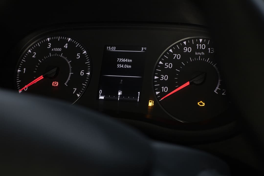 Painel de carro mostrando 73.564 km rodados, luz de combustível acesa e alerta de verificação do motor.