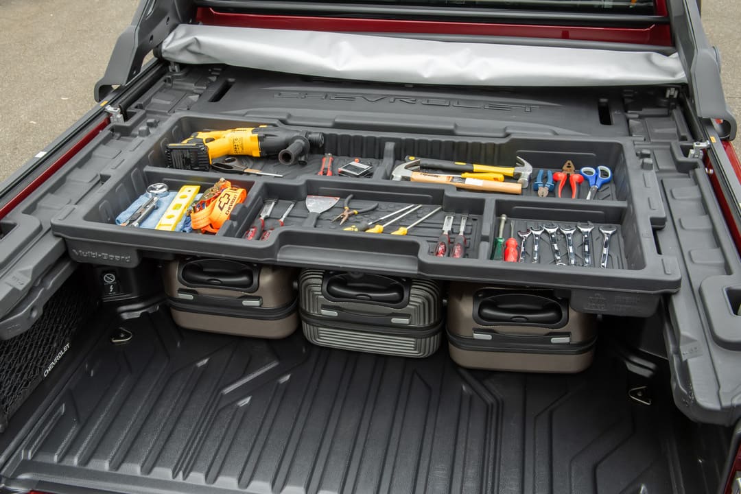 Organizador de ferramentas instalado na caçamba de uma picape Chevrolet com diversos acessórios manuais e elétricos.